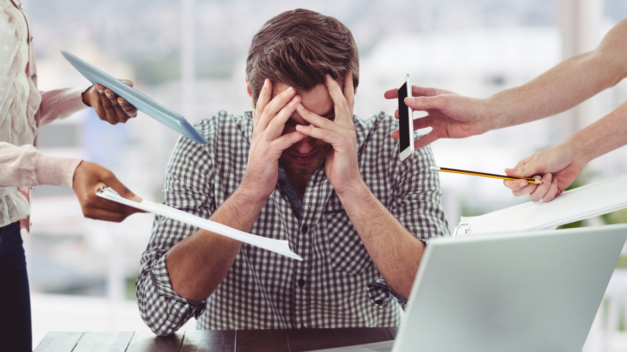 Stressed man frustrated with electronic devices in office